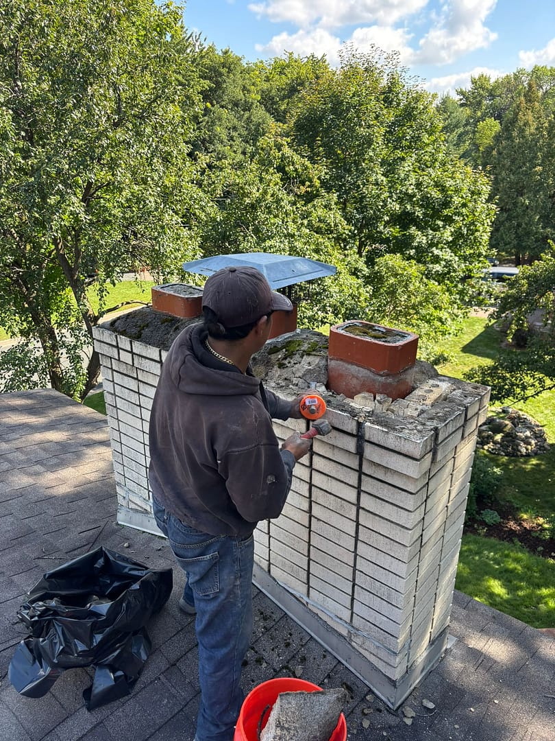 Technician performing chimney masonry repair in Minneapolis home